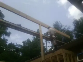 Carpenter setting a ridge beam over a new addition frame — Ice Dam Removal by Roofing Brothers in West Roxbury