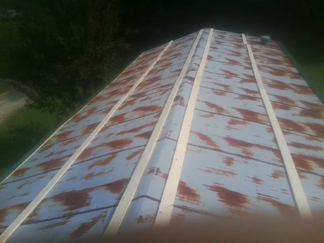 Rusted metal roof panels with new wood purlins before replacement — Storm Damage Roof Repair in West Roxbury by Roofing Brothers