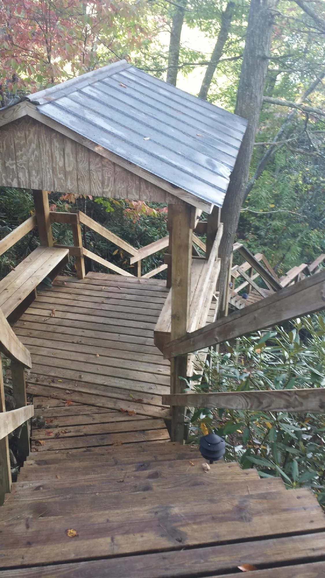 Metal roofed shelter over wooden steps on a wooded walkway — Skylight Repair & Installation work by our crew in West Roxbury